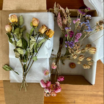Dried flowers in open cardboard boxes on a wooden surface